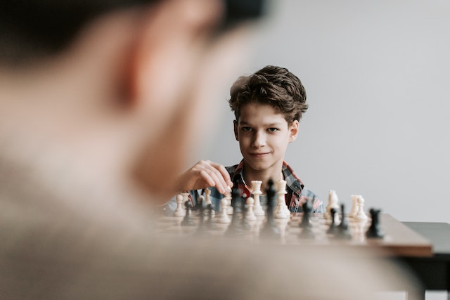 Młody chłopak gra w szachy