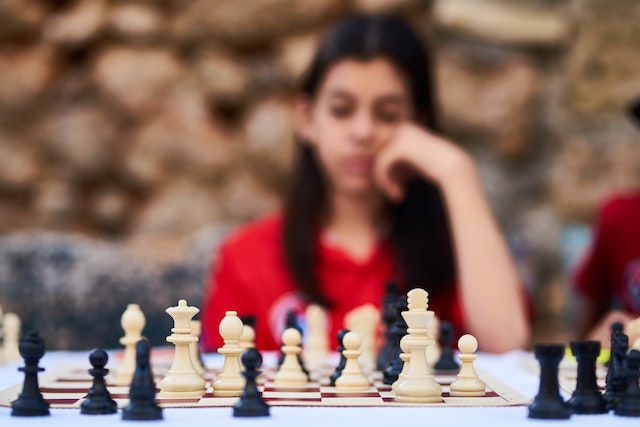 Skupiona dziewczyna grająca w szachy