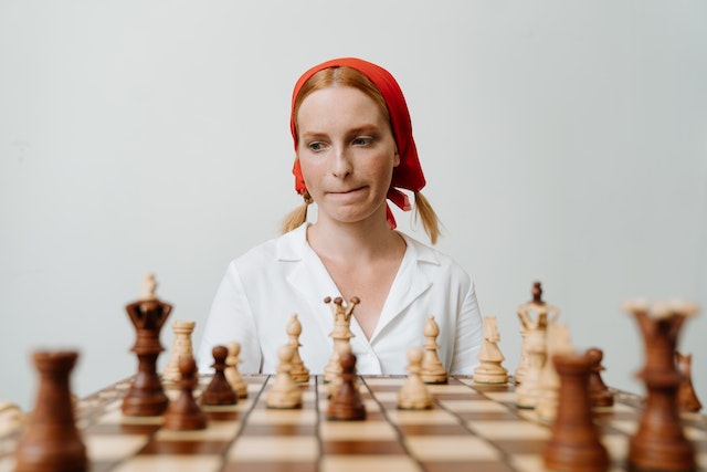 Kobieta zastanawiająca się nad ruchem w szachach